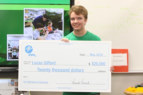 Scholarship Winner boy with large check