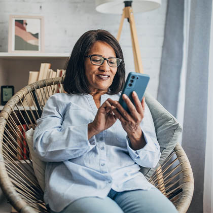 a woman sitting in a chair using her smartphone