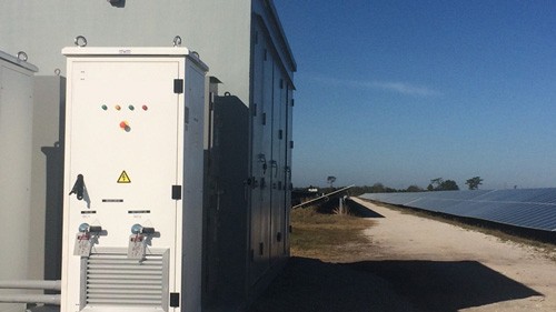 Side view of FPL Citrus Battery Storage System containers next to solar panels