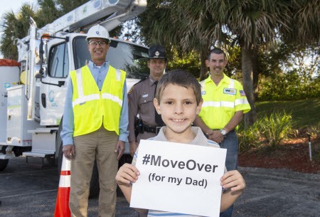 Boy holding #MoveOver For my Dad sign